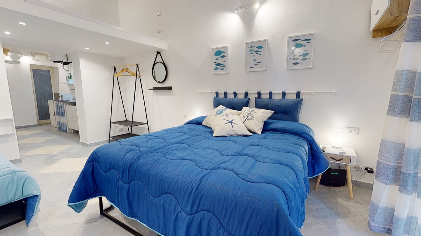 Camera con letto matrimoniale blu in un appartamento del centro storico di Palermo